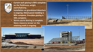 Tennis court fence, bleachers and field house